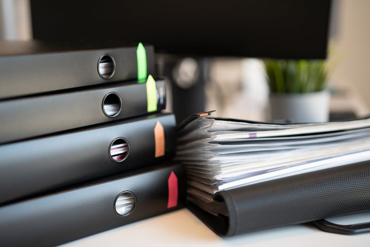 Several business paperwork files on a desk